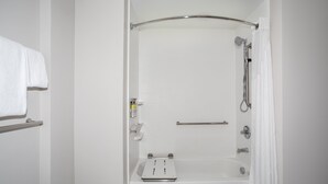 A white bathroom with a shower, a towel rack, and a soap dispenser. - Holiday Inn Express & Suites Sterling by IHG (Sterling)