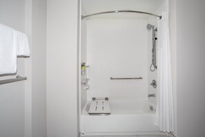 A white bathroom with a shower, a towel rack, and a soap dispenser. - Holiday Inn Express & Suites Sterling by IHG (Sterling)