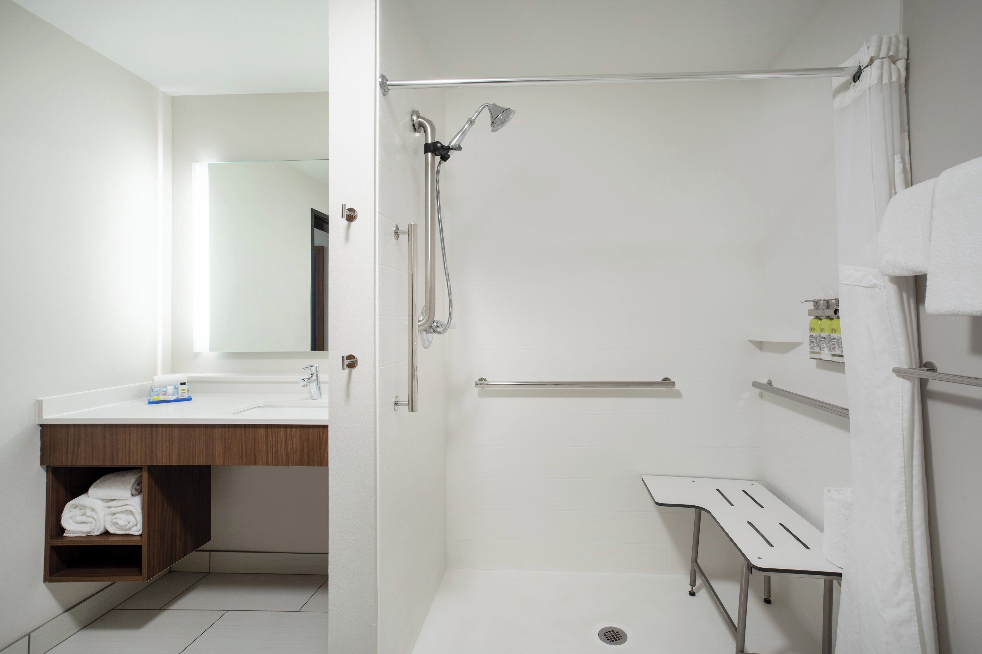 A modern bathroom with a shower, a sink, and a mirror.
