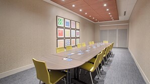 A conference room with a long table, yellow chairs, and framed artwork on the wall. - Holiday Inn Express & Suites Sterling by IHG (Sterling)