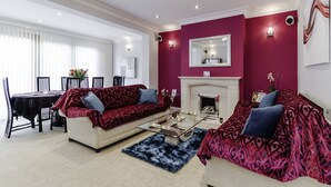 Een woonkamer met twee banken, een salontafel en een open haard.