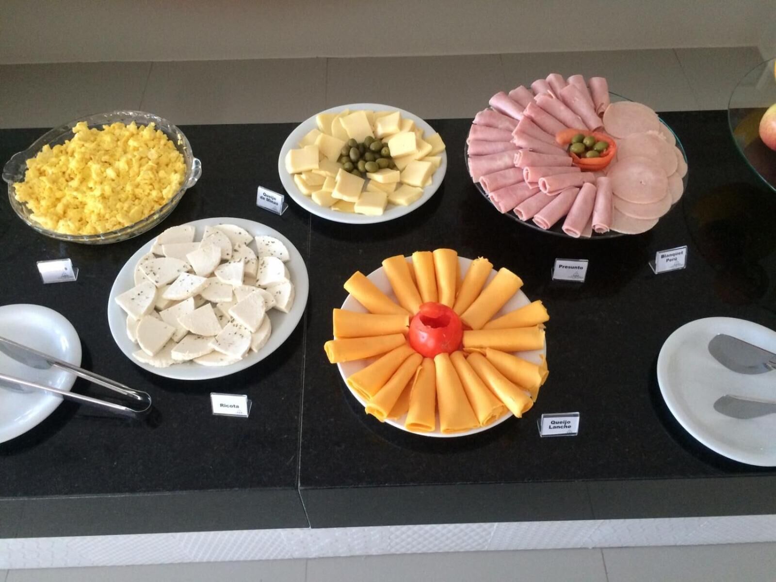 A buffet table with various food items including cheese, ham, and other dishes.