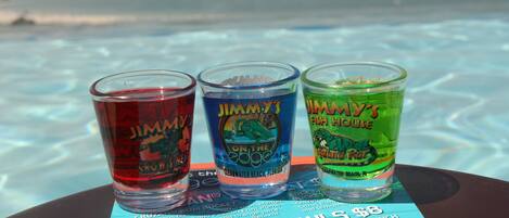 Three Jimmy John's branded shot glasses on a menu board.
