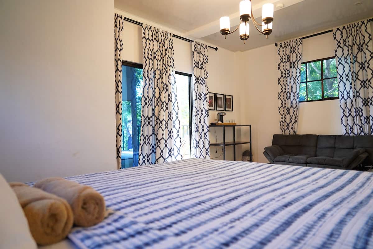 Un dormitorio con una cama grande, un sofá y un escritorio.