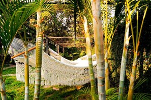 A hammock in a lush garden with bamboo trees. - Hotel Alma Azul (El Cuco)