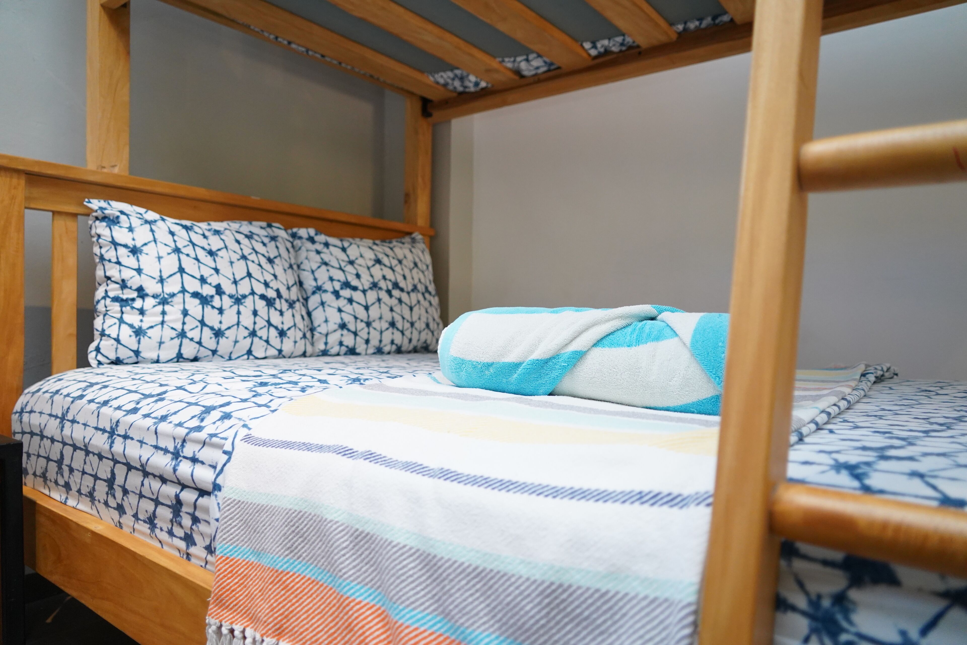 A bunk bed with a patterned bedspread and pillows.