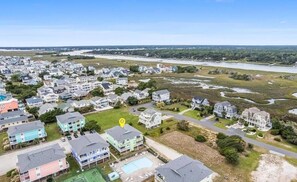Vista aérea de una zona residencial costera con casas, una playa y un río.