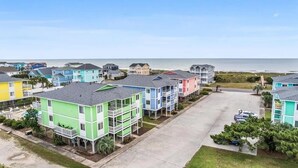 Zona residencial frente a la playa con casas coloridas, cielo despejado y vista al océano.