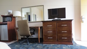 A hotel room with a desk, chair, wardrobe, and a television. - Laguna Lodge (Marina)