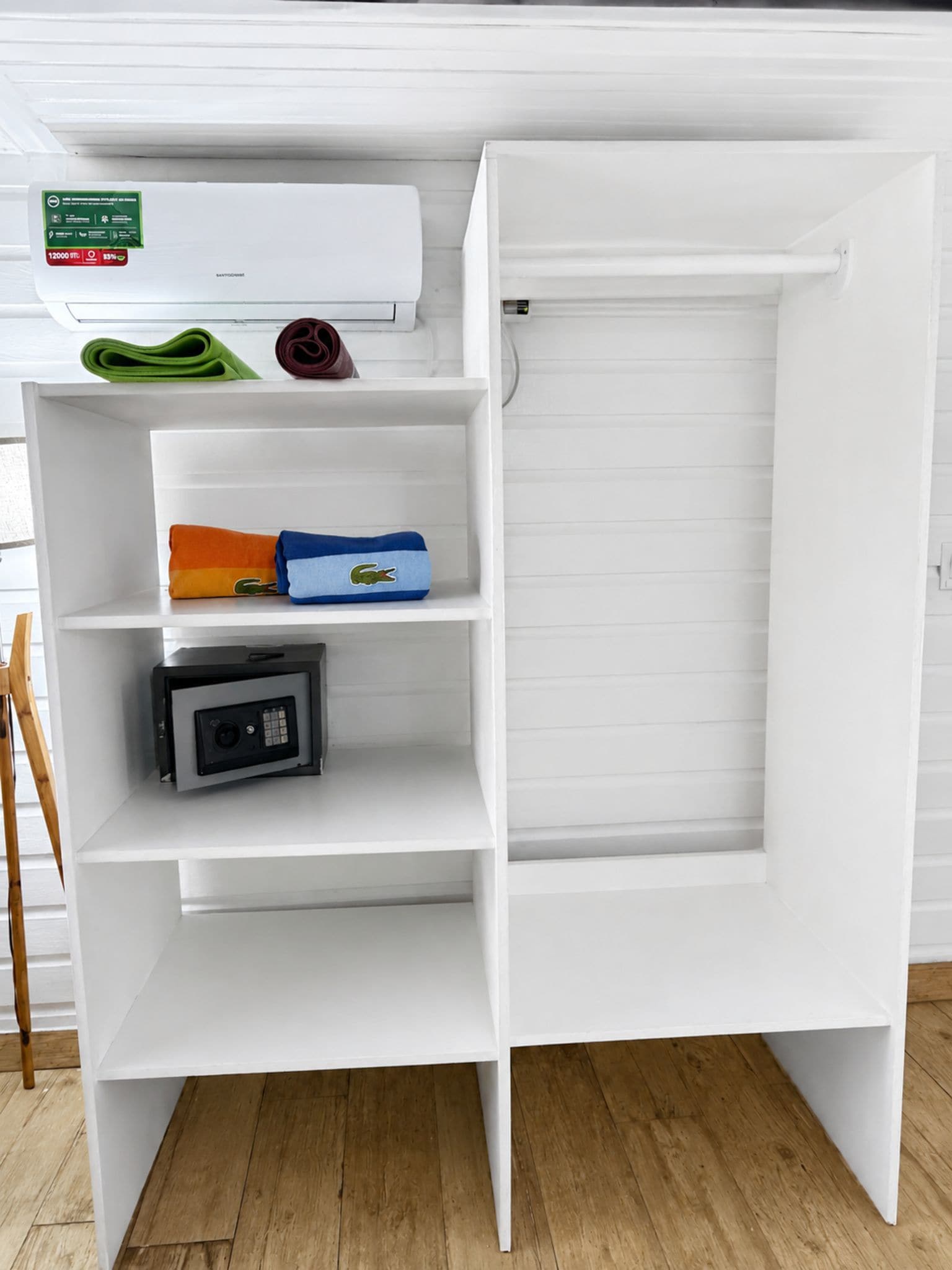 Un mini-réfrigérateur blanc doté d’un appareil à glaçons intégré, d’un petit compartiment congélateur et d’une étagère sur laquelle se trouvent une serviette verte et un objet marron.
