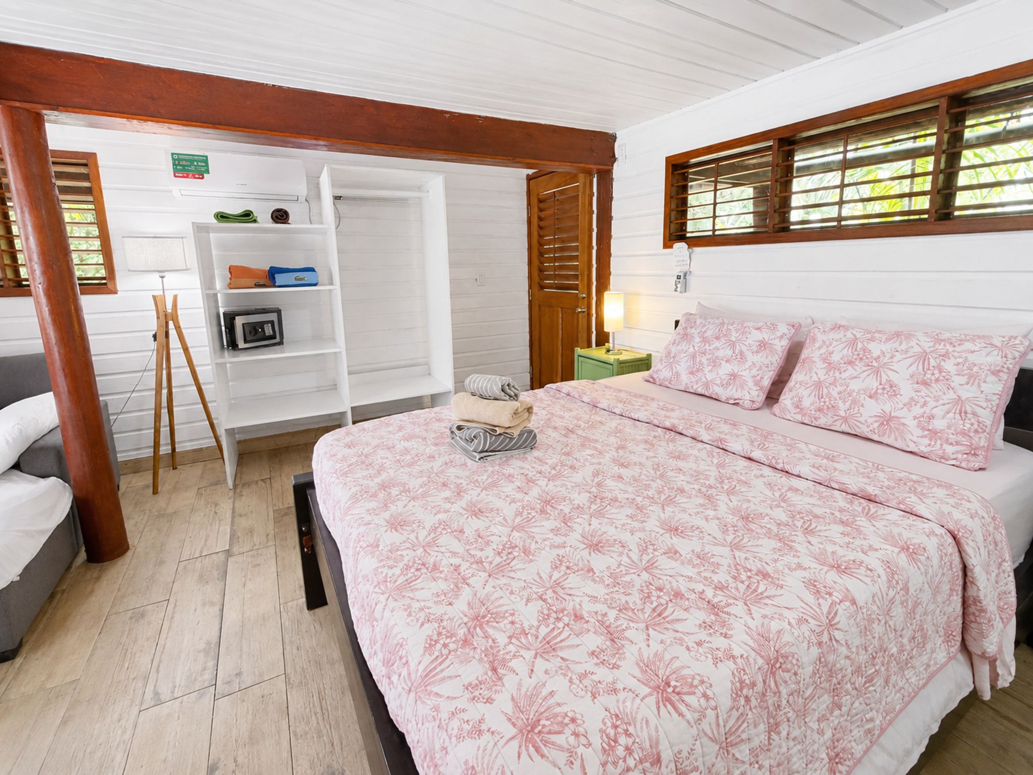 Un dormitorio con cama, armario y una mesita de noche con lámpara.