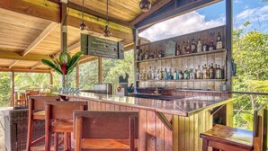 A wooden bar area with a selection of spirits and a sign indicating a craft brewery. - Oasis Bluff Beach (Bocas del Toro)