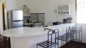A modern kitchen with a central island, white cabinetry, and a stove.