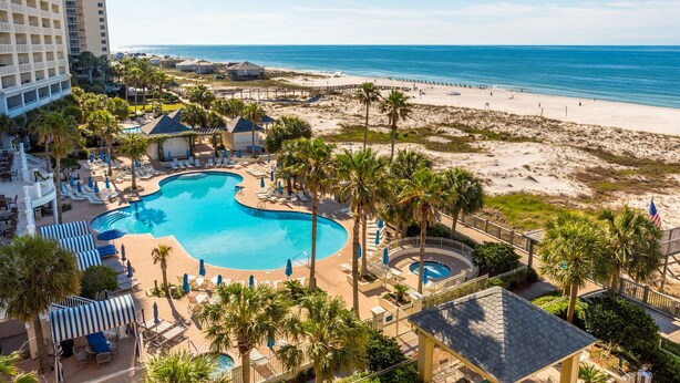 Ett semesterhotell med en stor pool, tillgång till stranden och utsikt över havet.