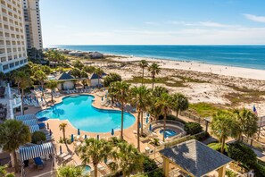 Un resort con una amplia piscina, acceso a la playa y vista al océano.