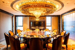 A luxurious conference room with a large round table, comfortable leather chairs, a grand chandelier, and a large screen. - Shanghai Ship Hotel (Shanghai)
