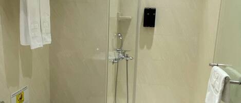 A modern bathroom with a glass-enclosed shower, a toilet, and a sink.