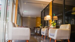 A modern lobby with a row of seating, a reception desk, and a large window. - The Koos Hotel Dahu (Taipei)
