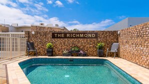 Een zwembad met een bakstenen muur en een bord waarop 'THE RICHMOND' staat.
