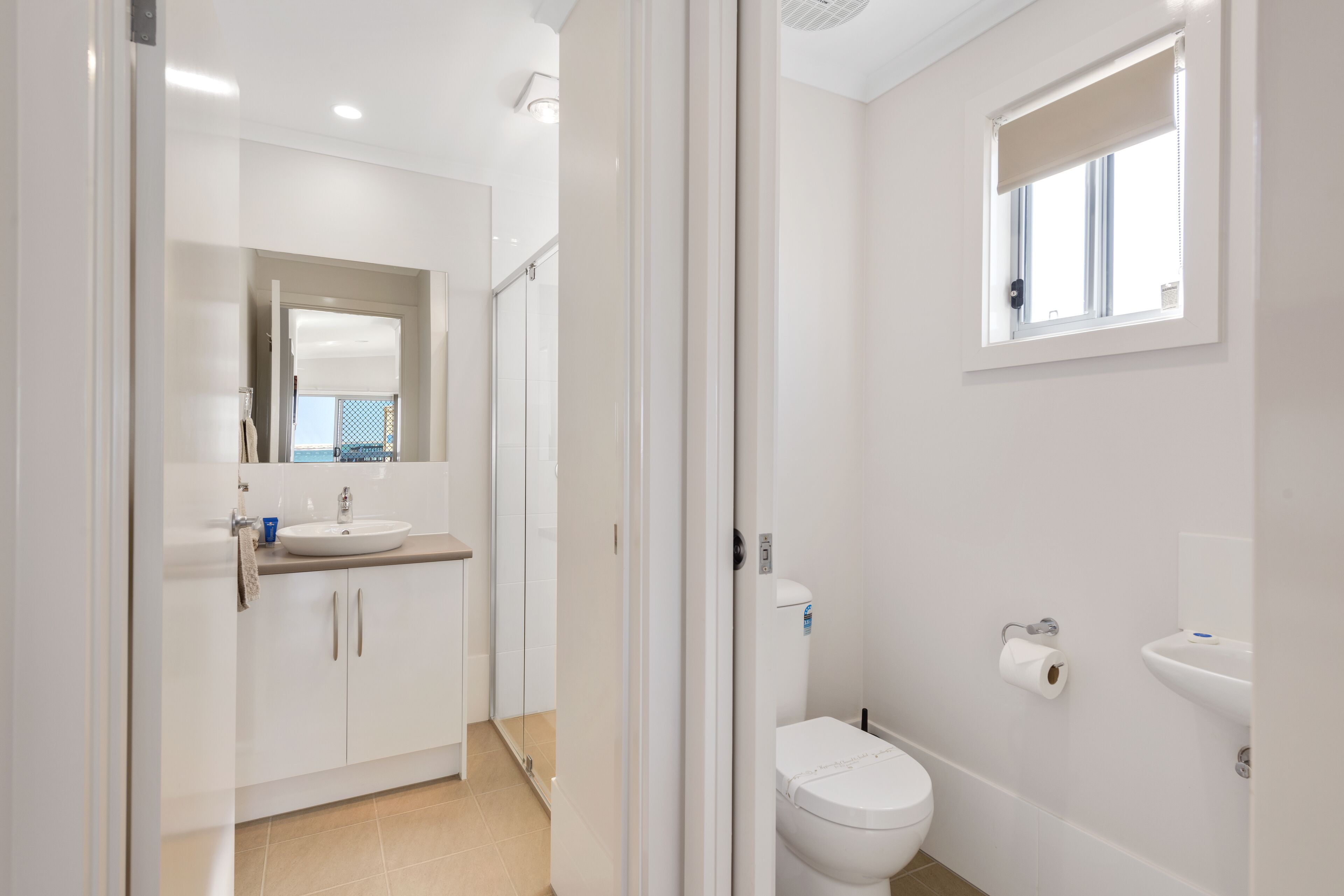 Une salle de bain moderne équipée de toilettes, d’un lavabo et d’une zone douche.
