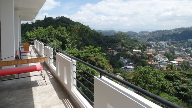 Un balcon donnant sur la ville et les collines.