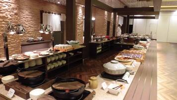 A buffet setup with various food items and serving utensils.