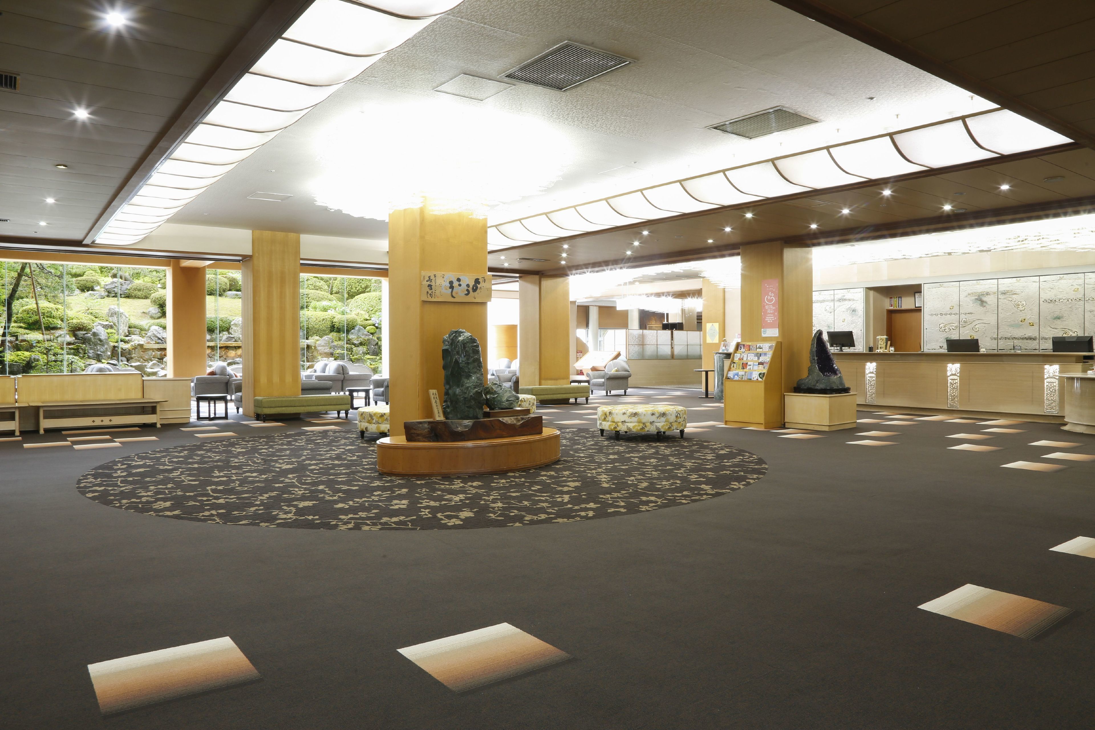 A spacious lobby with a central fountain, seating areas, and a reception desk.