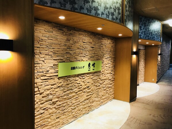 A reception area with a stone wall and a green sign with Japanese characters.