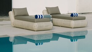 Two wicker lounge chairs with cushions by a clear pool. - Seda Vertis North Quezon City (Quezon City)