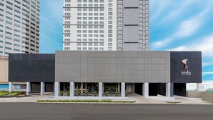 A modern hotel building with a prominent 'Seda' sign, featuring a clean, structured facade with multiple floors and a parking area in front. - Seda Vertis North Quezon City (Quezon City)