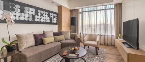 A modern living room with a sectional sofa, a round coffee table, and a television.