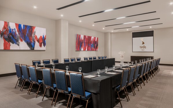 A conference room with a long table, blue chairs, and abstract art on the walls. - Seda Vertis North Quezon City (Quezon City)