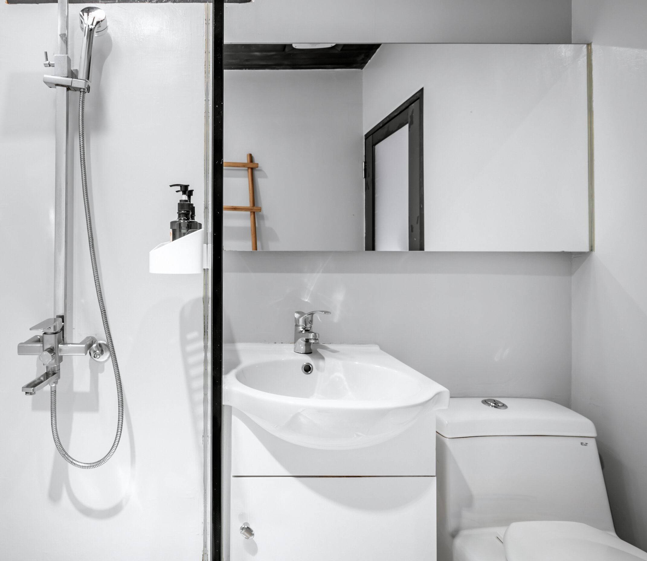A modern bathroom with a shower, sink, and toilet.