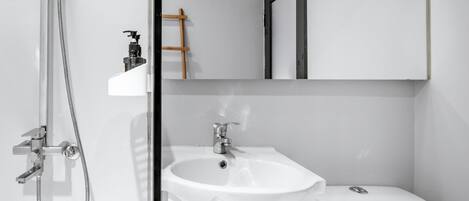 Un baño moderno con ducha, lavabo e inodoro.
