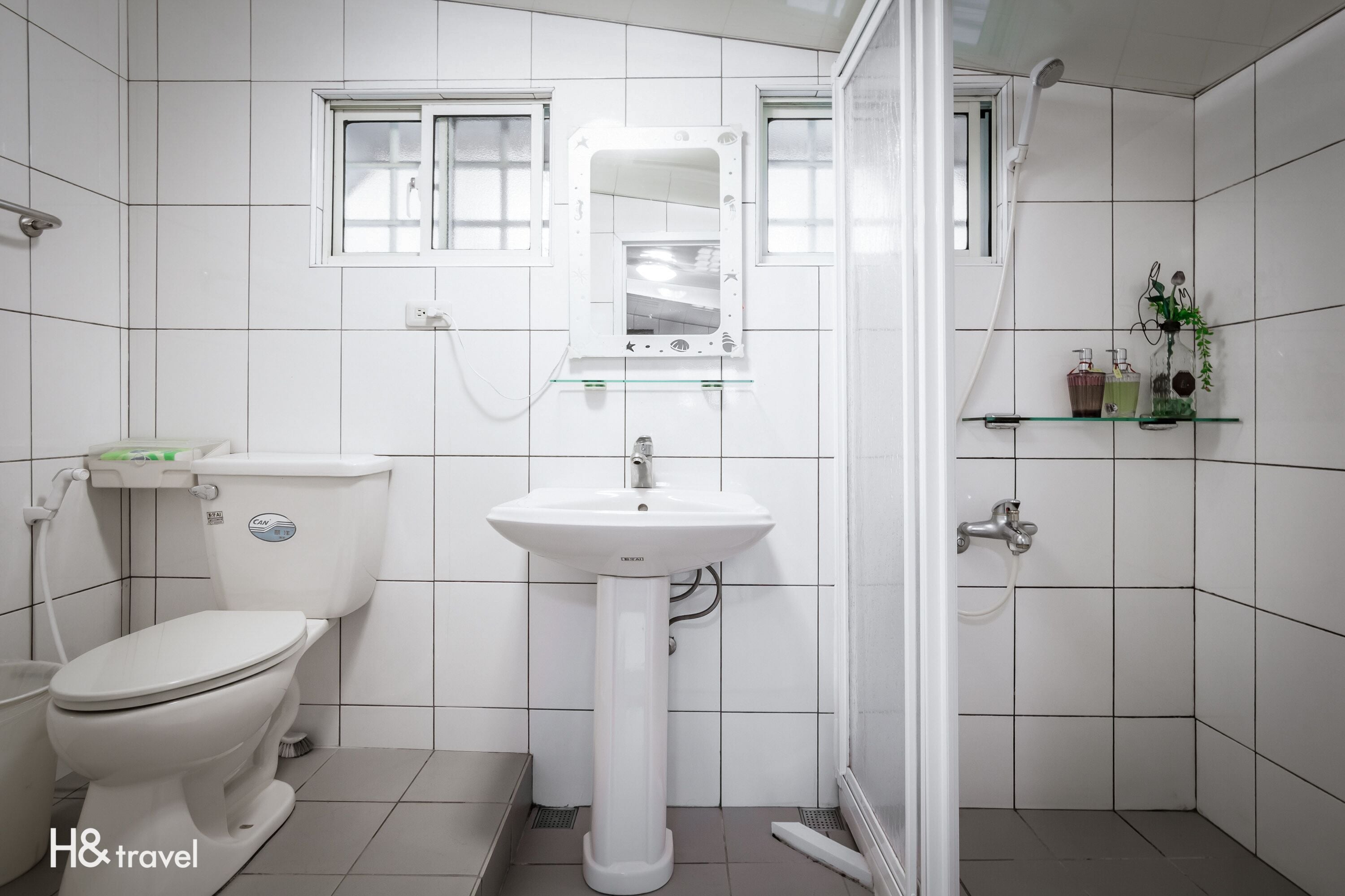 A bathroom with a toilet, sink, and shower.