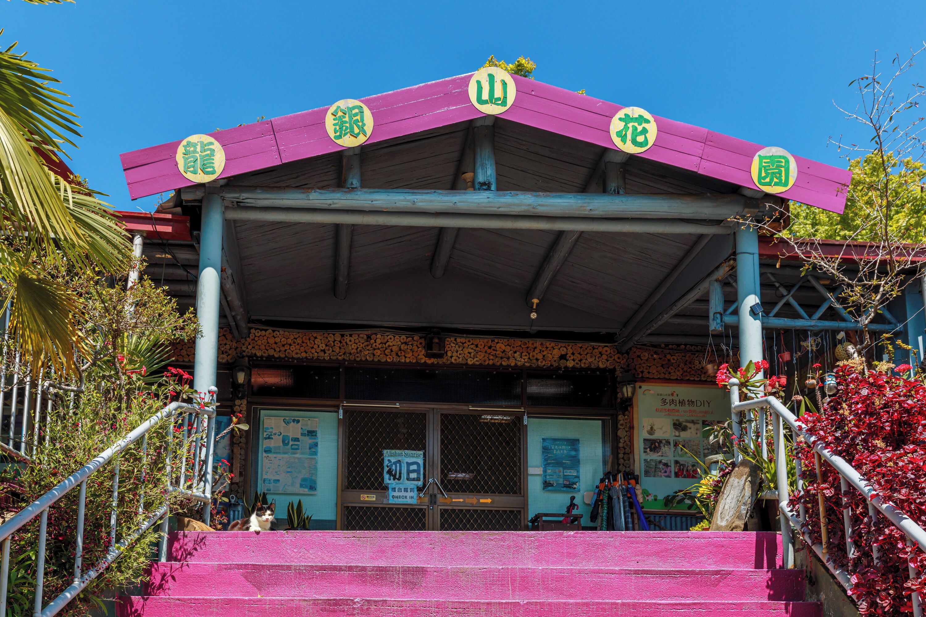 A building with a pink roof and a sign with Chinese characters.