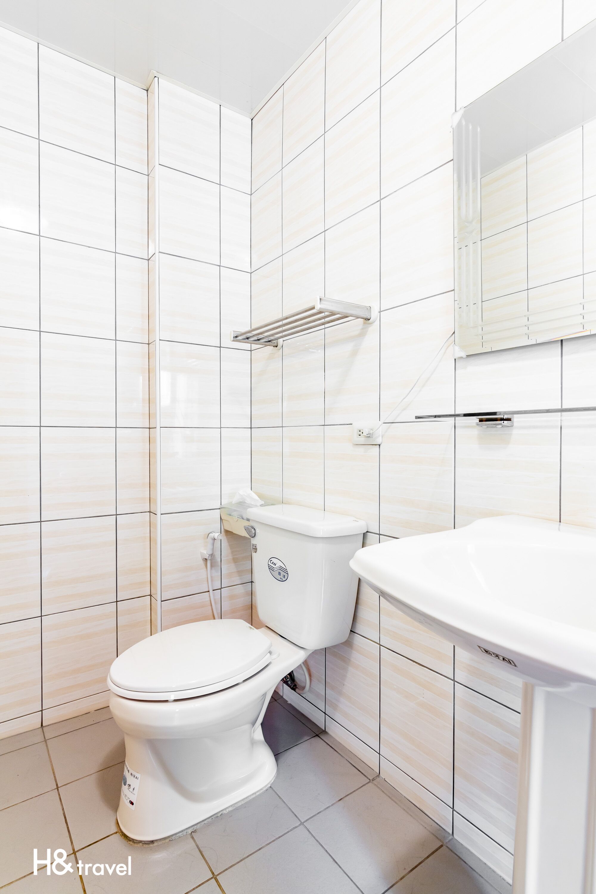Un baño con inodoro, lavamanos y espejo.