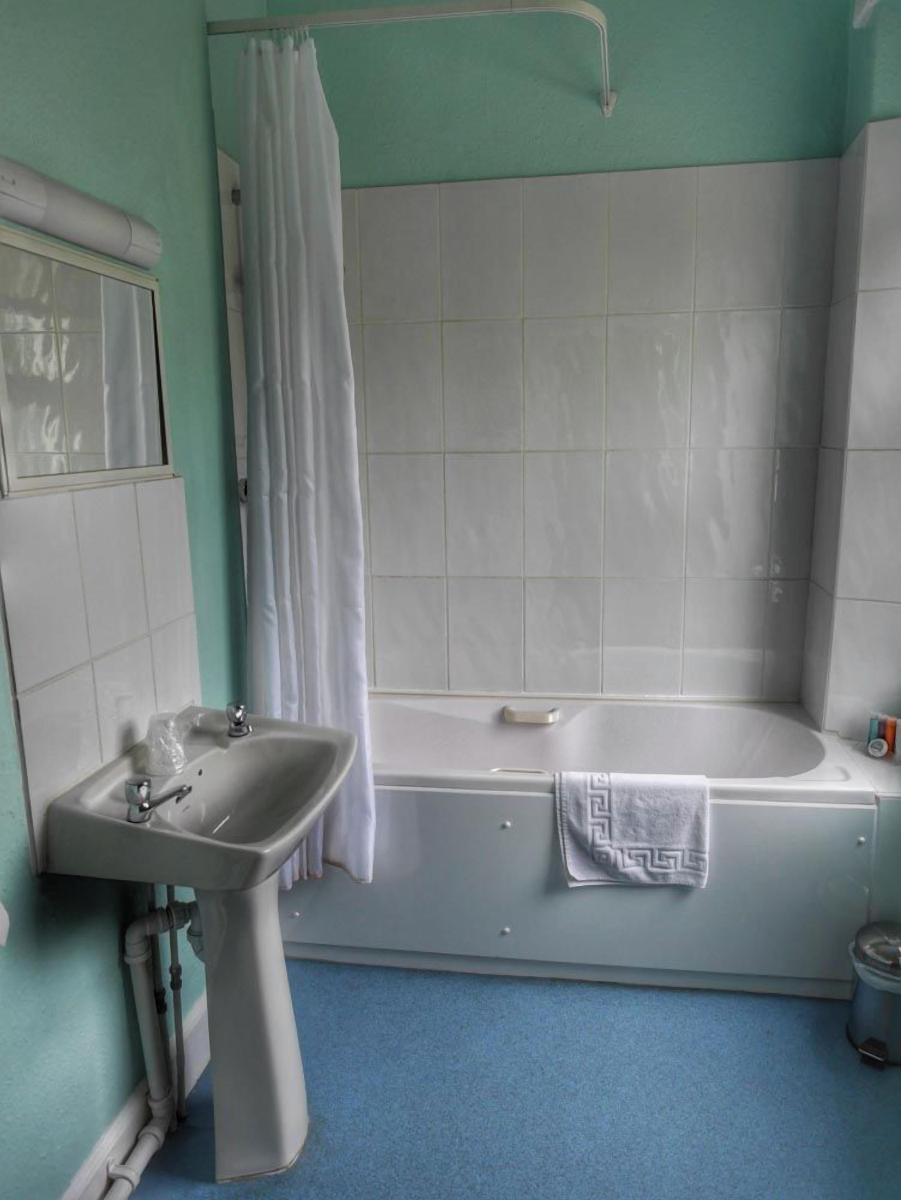 Un baño con lavamanos, bañera y cortina de ducha.