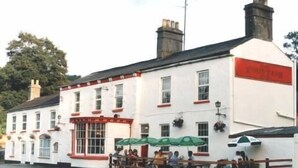 A white building with a red sign reading "The Red Lion." - The Fountain Inn (Lydney)