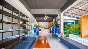 A modern interior with a long wooden table, seating, and shelves with books. - Anantaya Home Phare (Sung Men)