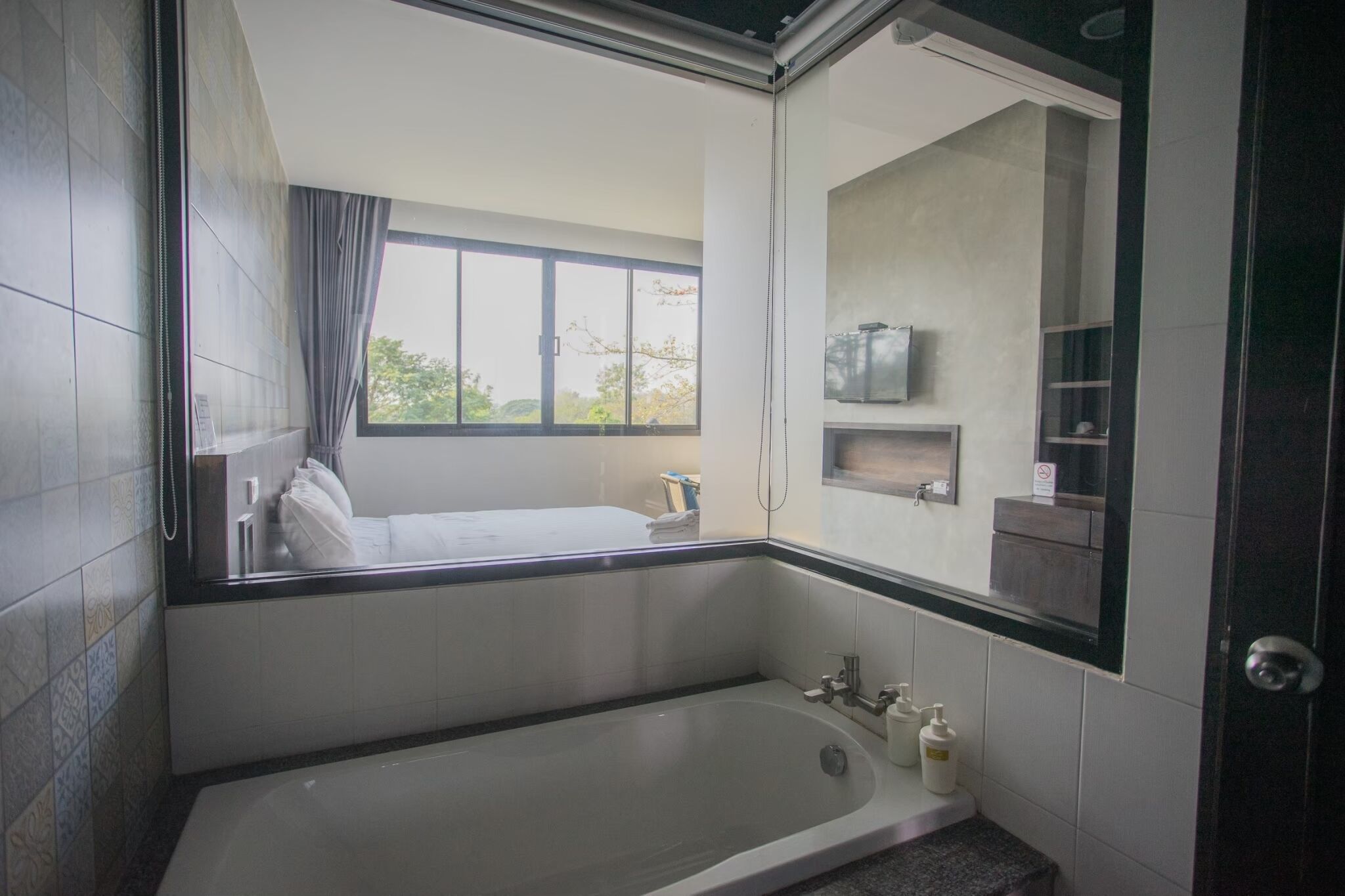 Un baño moderno con una bañera grande, una ventana con vistas y un espejo.