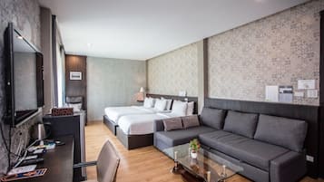 Una habitación de hotel moderna con dos camas, un sofá, un escritorio y un televisor.