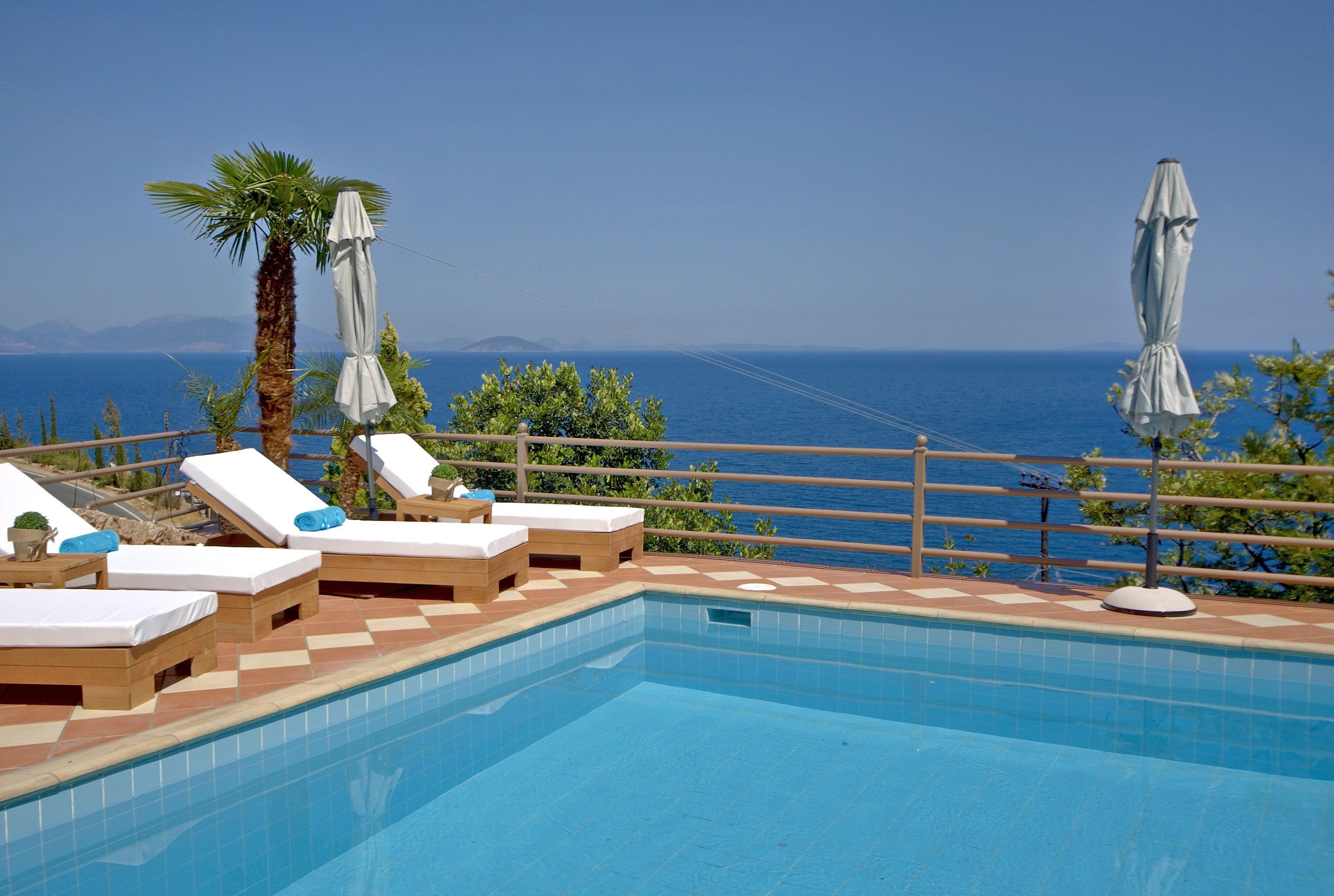 Een buitenzwembad, parasols bij het zwembad en ligstoelen