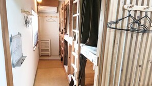 A narrow hallway with wooden bunk beds, a small mat on the floor, and a calendar on the wall. - Harimayabashi Guest House - Hostel (Kochi)