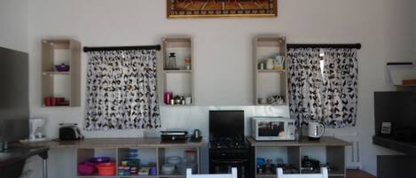 Cocina compacta con una mesa de comedor, sillas, microondas y estufa.