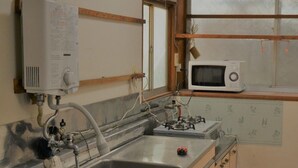 A kitchen with a double sink, a microwave, and a water heater.