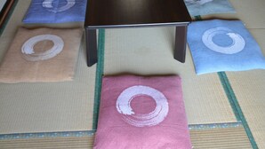 A tatami mat room with a low table and a futon bed.