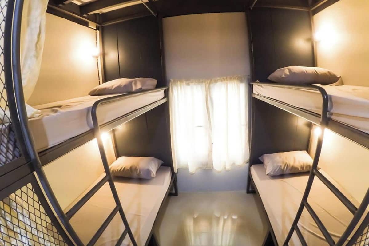 A bunk bed room with a curtain and a window.