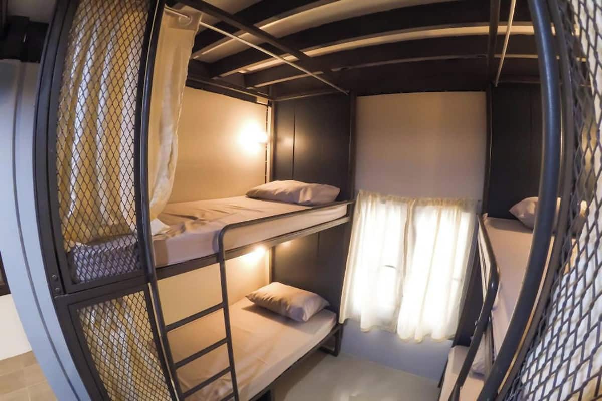 A bunk bed room with a mesh partition and curtains.