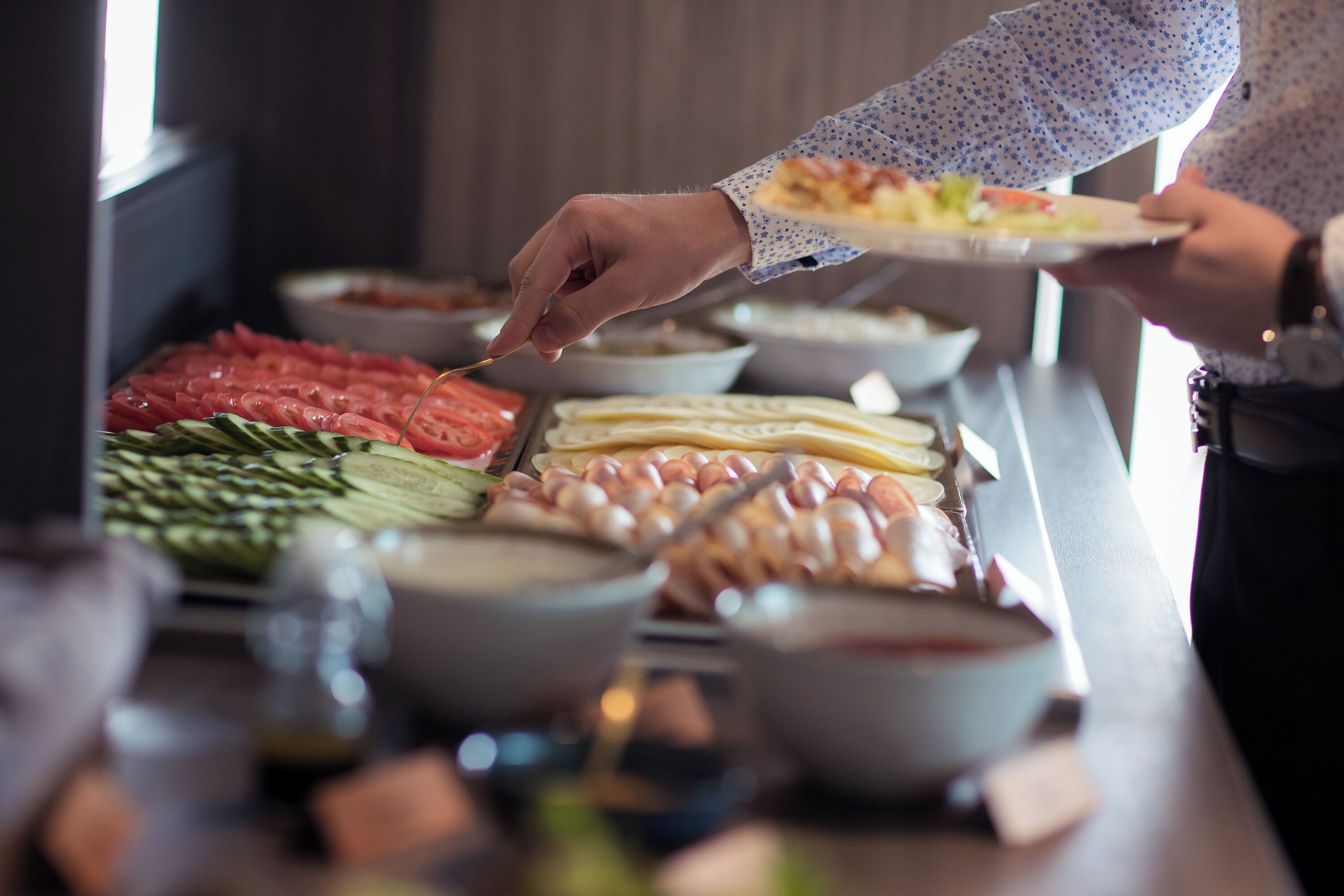 Un bufé con una variedad de alimentos, incluyendo carnes, verduras y salsas.
